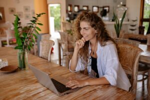 Person smiling while looking into laptop screen